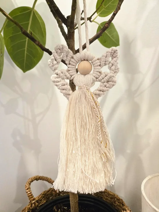 Small natural macramé angel hanging in a ficus tree