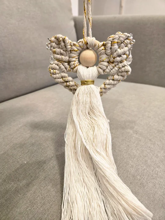 Cream macramé angel with curled wings and a long flowing skirt