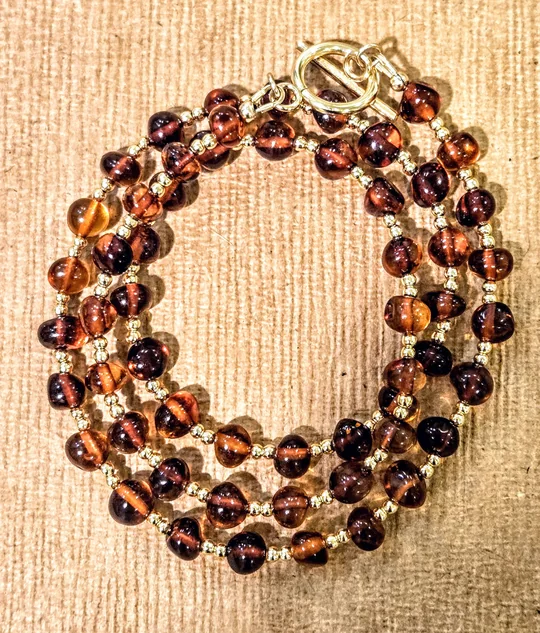 Deep cognac Baltic amber necklace with tiny gold beads and a gold toggle clasp