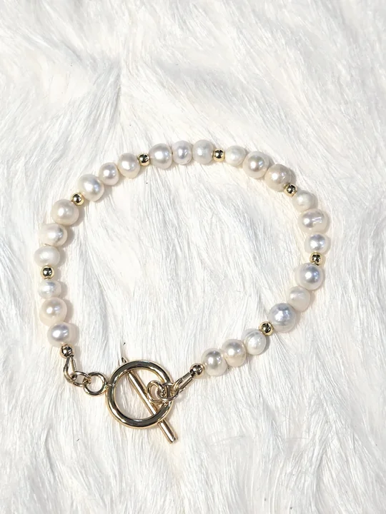 Bright white freshwater pearl bracelet with 14k gold-filled beads and a gold OT toggle clasp, on white fur