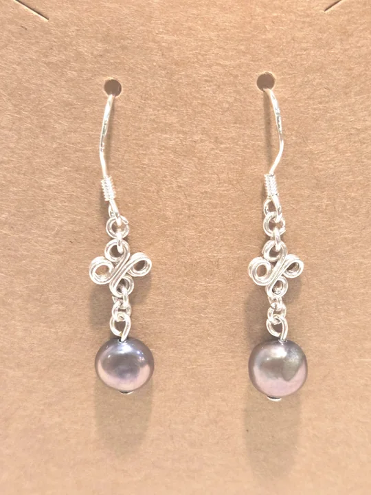 Purple-wine pearl earrings with sterling silver flowers, on a kraft card