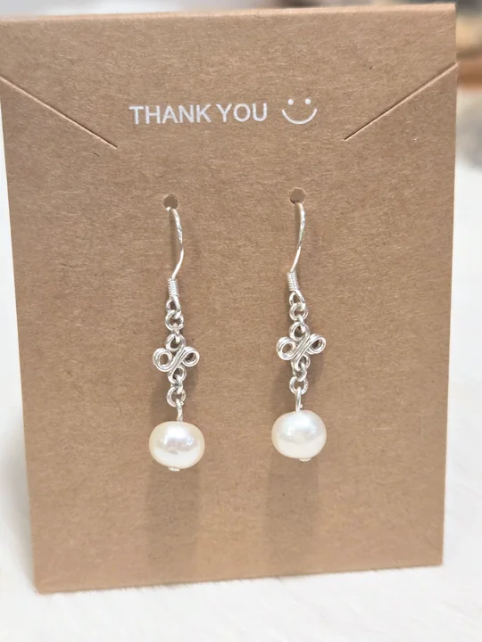 Large cream pearl earrings with sterling silver flowers, on a kraft card